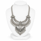 Silver necklace on a white mannequin bust against a white background