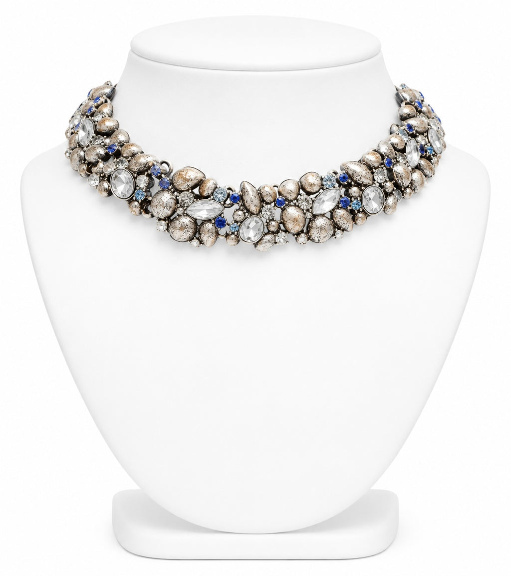 Elegant necklace with pearls and blue stones on a white stand