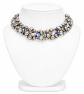 Elegant necklace with pearls and blue stones on a white stand