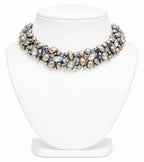 Elegant necklace with pearls and blue stones on a white stand