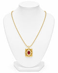 Gold necklace with a red gemstone pendant on a white mannequin bust.