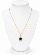 Gold necklace with a green teardrop pendant and diamond accents on a white background