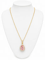 Gold necklace with a pink teardrop pendant on a white mannequin bust.