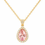 Gold necklace with a pink teardrop-shaped gemstone pendant on a white background