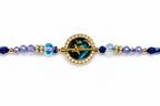 A celestial-themed gold-plated beaded bracelet featuring a central round medallion with a star motif over a green nebula pattern, surrounded by a halo of small clear crystals. The bracelet extends outward with faceted beads in shades of blue, purple, and iridescent teal, accented with gold spacer beads, all set against a plain white background.