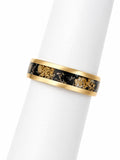 Gold ring with black and gold stone inlay on a white background