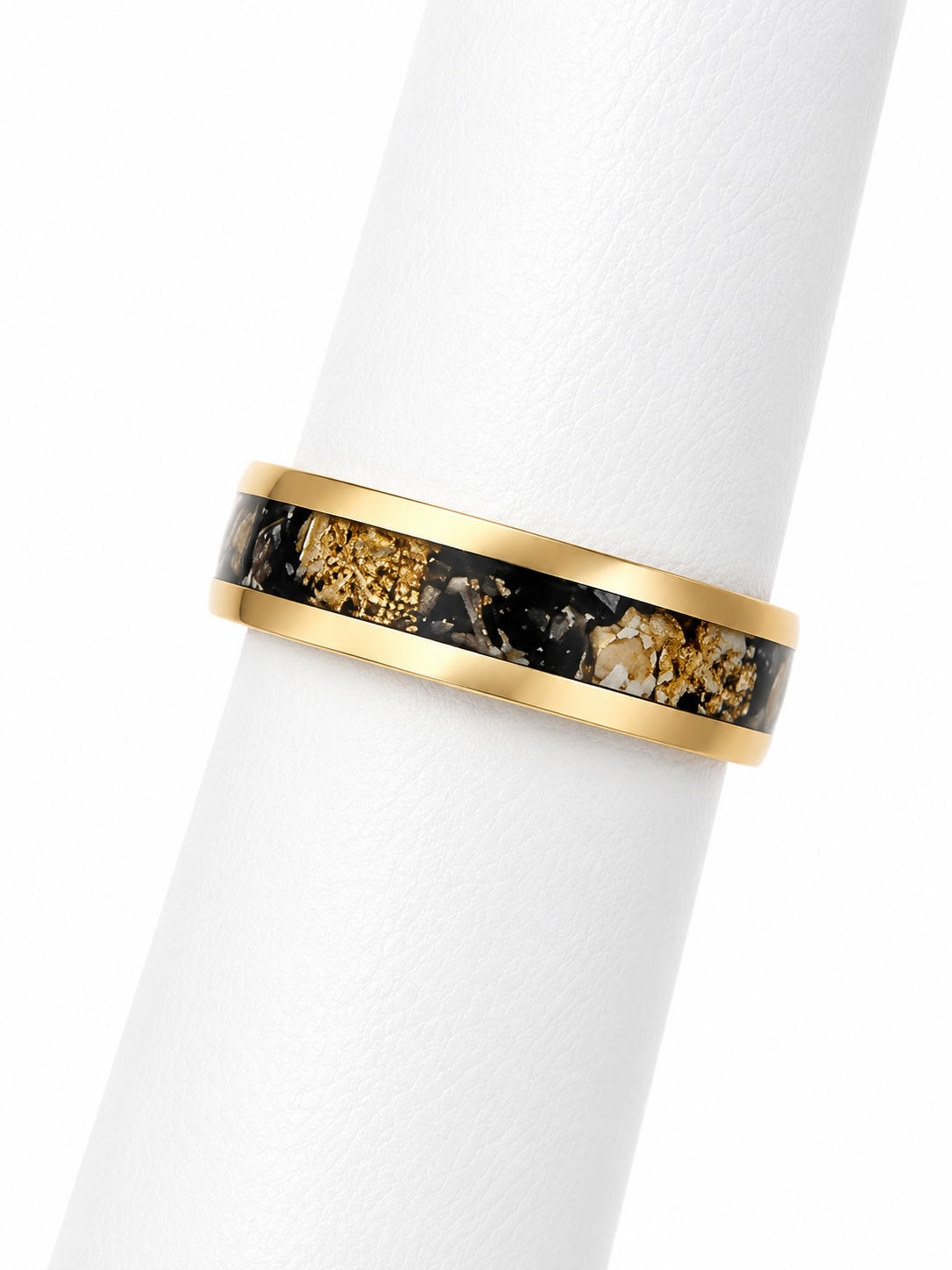 Gold ring with black and gold stone inlay on a white background