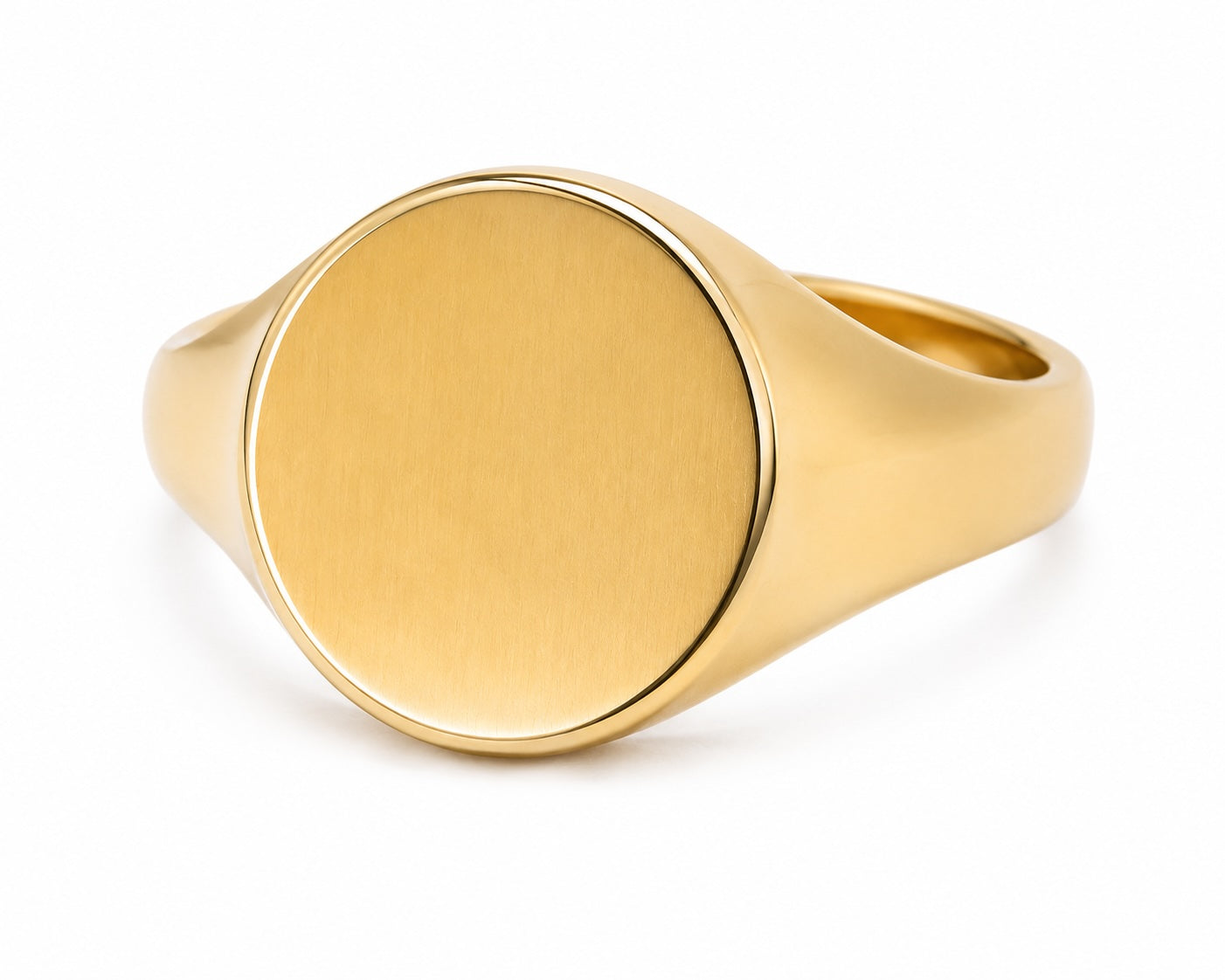 Gold ring with a flat, round surface on a white background