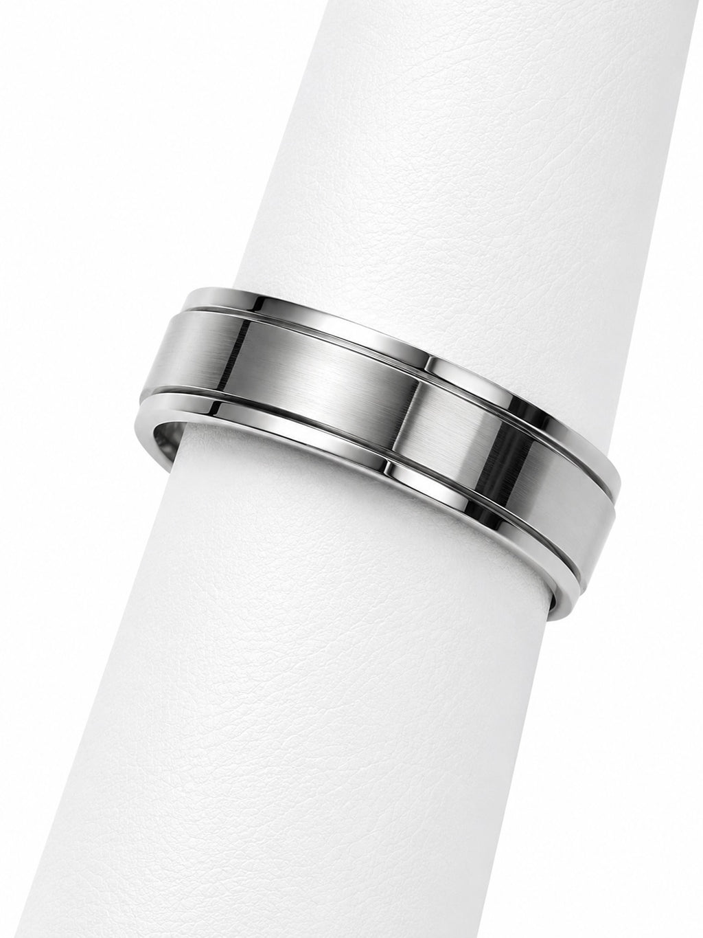 Silver ring on a white cylindrical object with a white background
