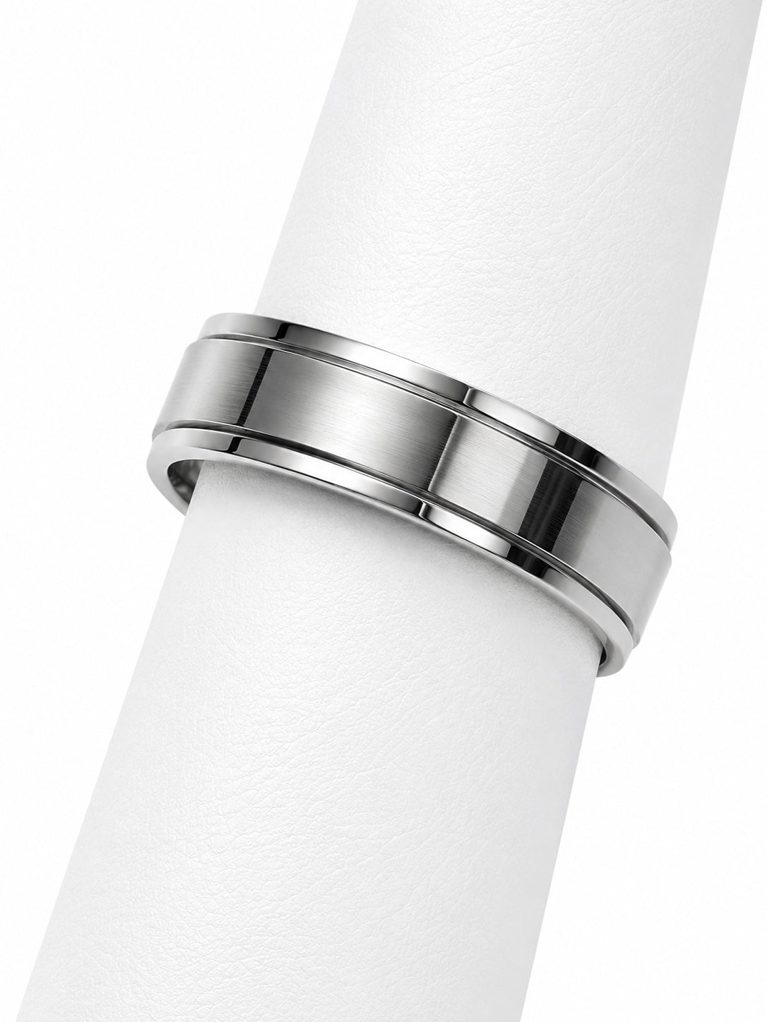 Silver ring on a white cylindrical object with a white background