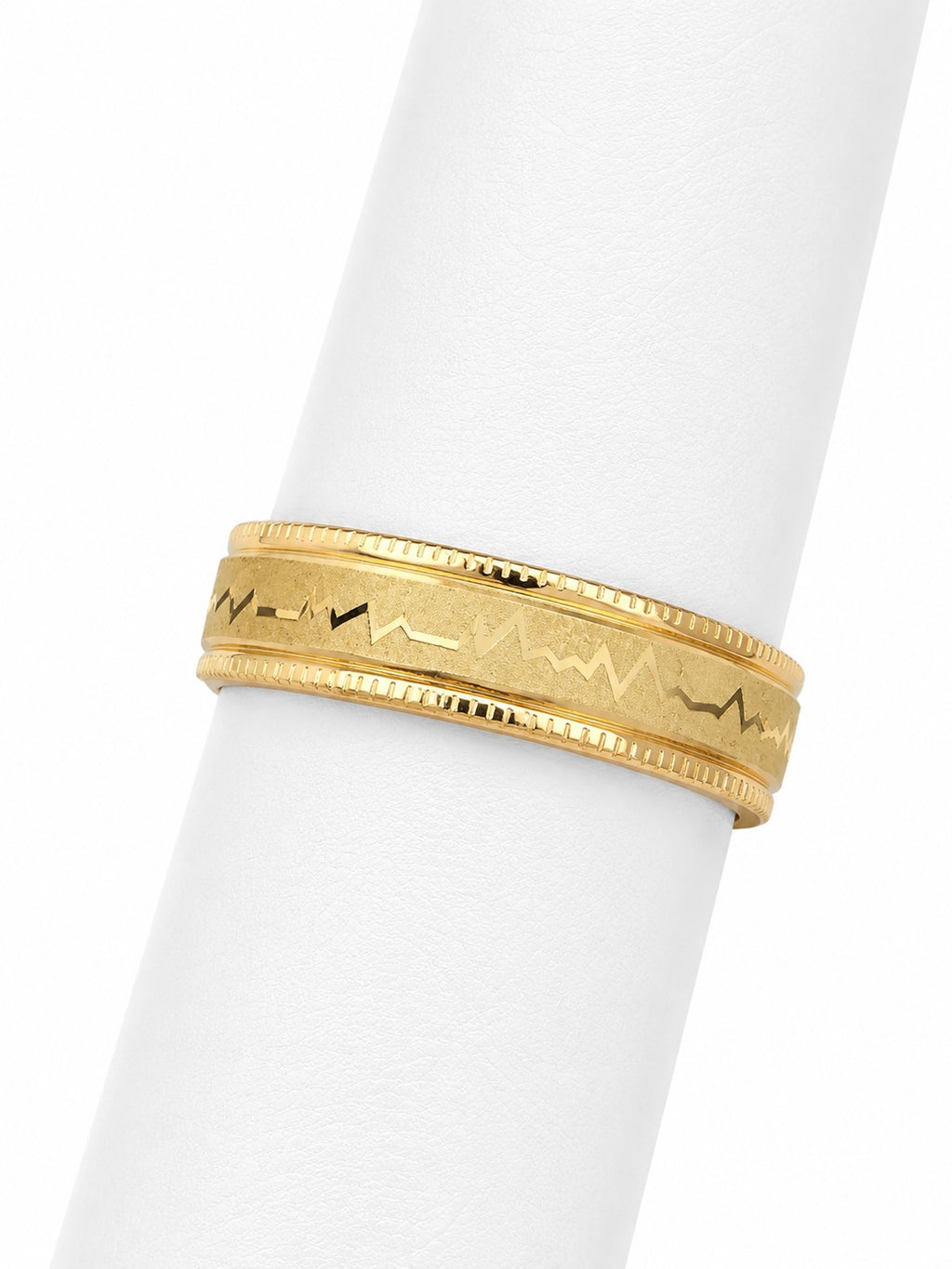 Gold ring with intricate design on a white background