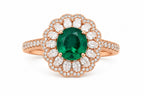 Rose gold ring with a green gemstone and diamond accents on a white background