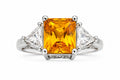 Ring with a yellow gemstone and triangular diamonds on a white background