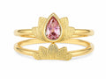 Gold ring with a pink gemstone on a white background