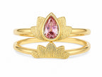Gold ring with a pink gemstone on a white background