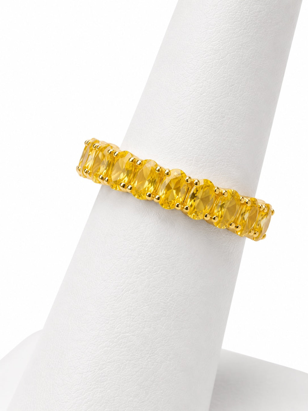 Yellow gemstone ring on a white stand