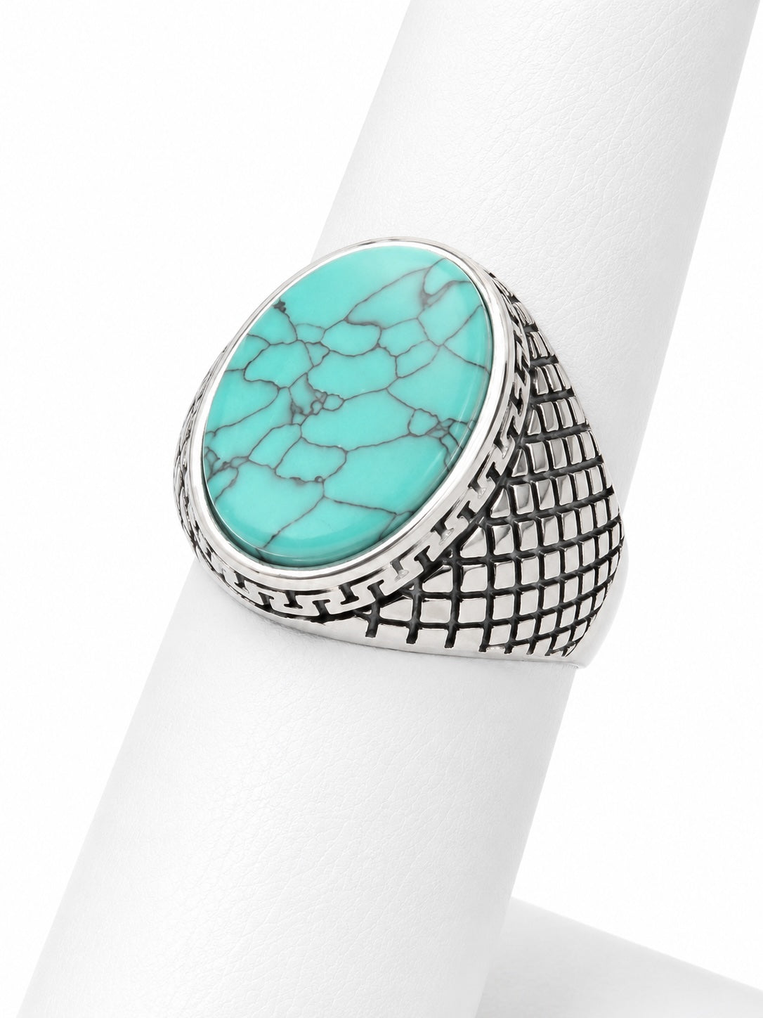 Turquoise stone ring with silver band on a white stand