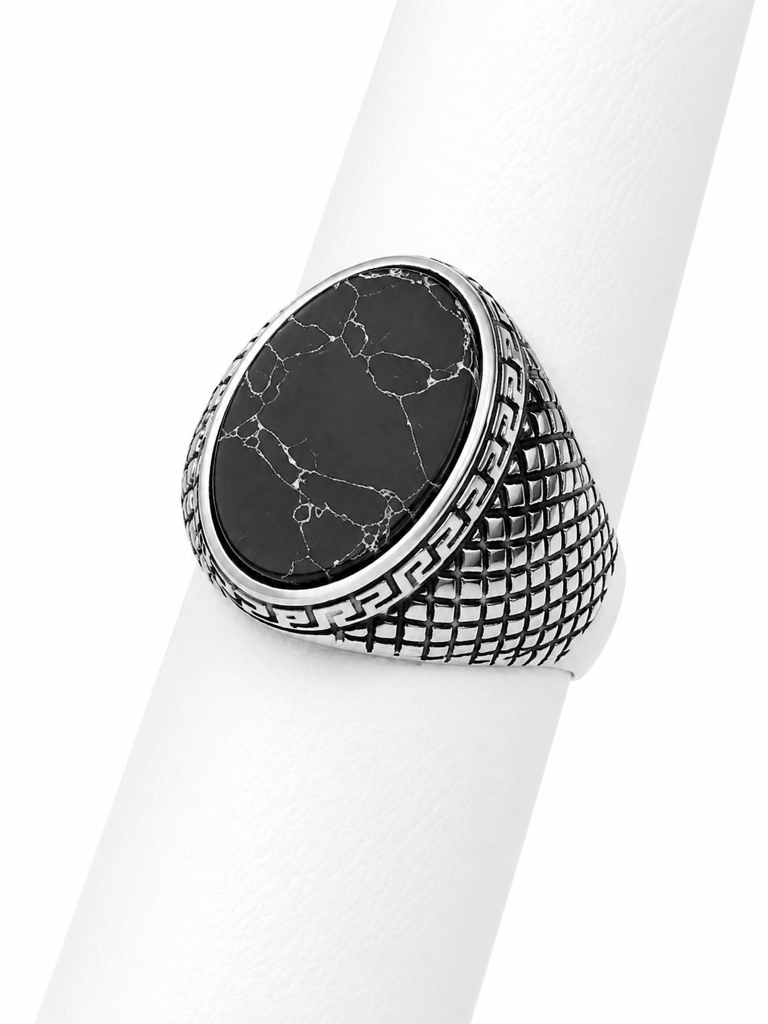 Silver ring with black marble stone on a white background