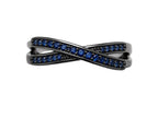 Black cross-shaped ring with blue gemstones on a white background