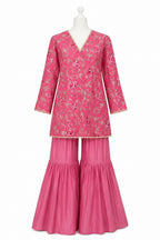 Pink traditional outfit with floral patterns on a white background