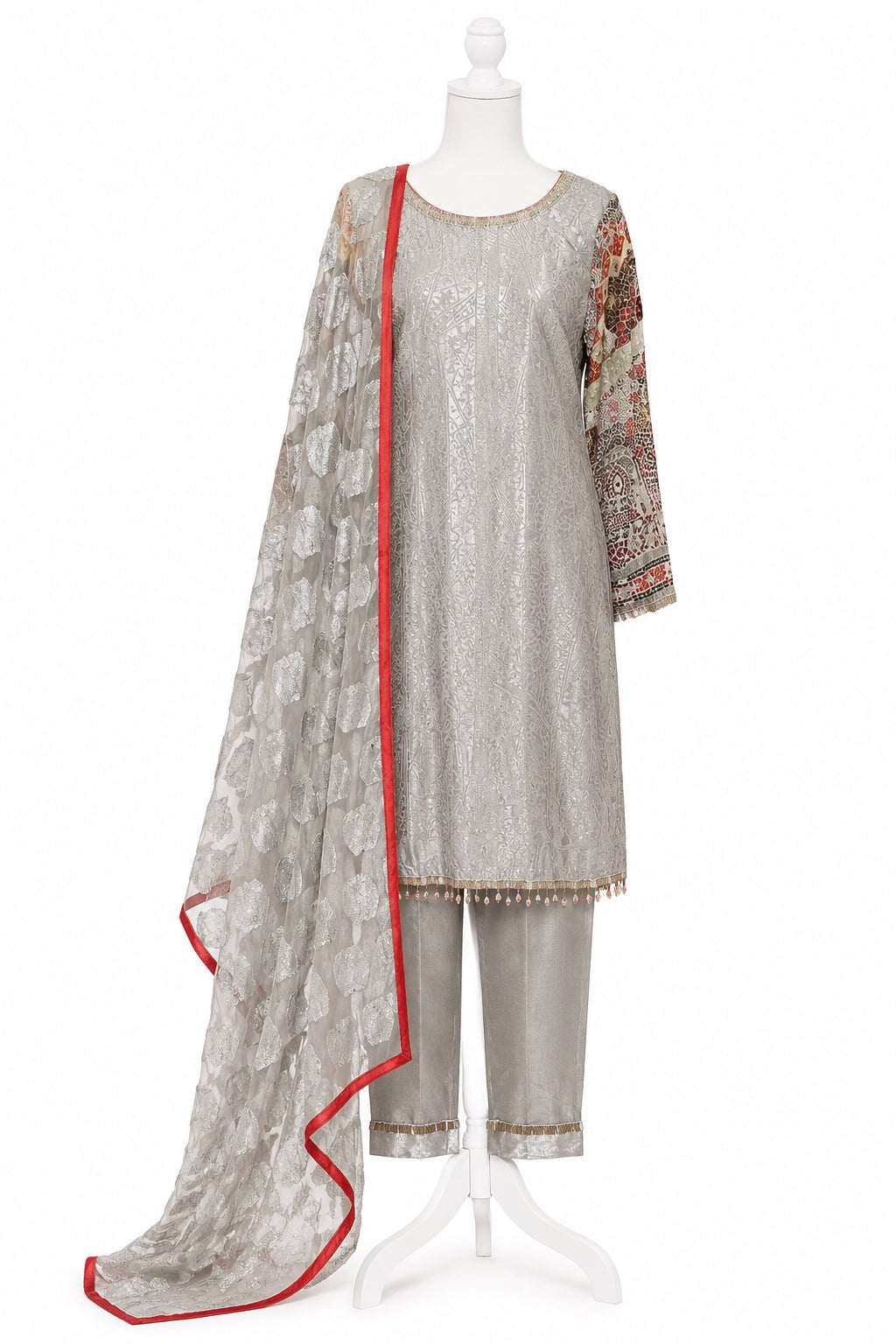 Traditional outfit with a silver and red embroidered dress on a mannequin against a white background